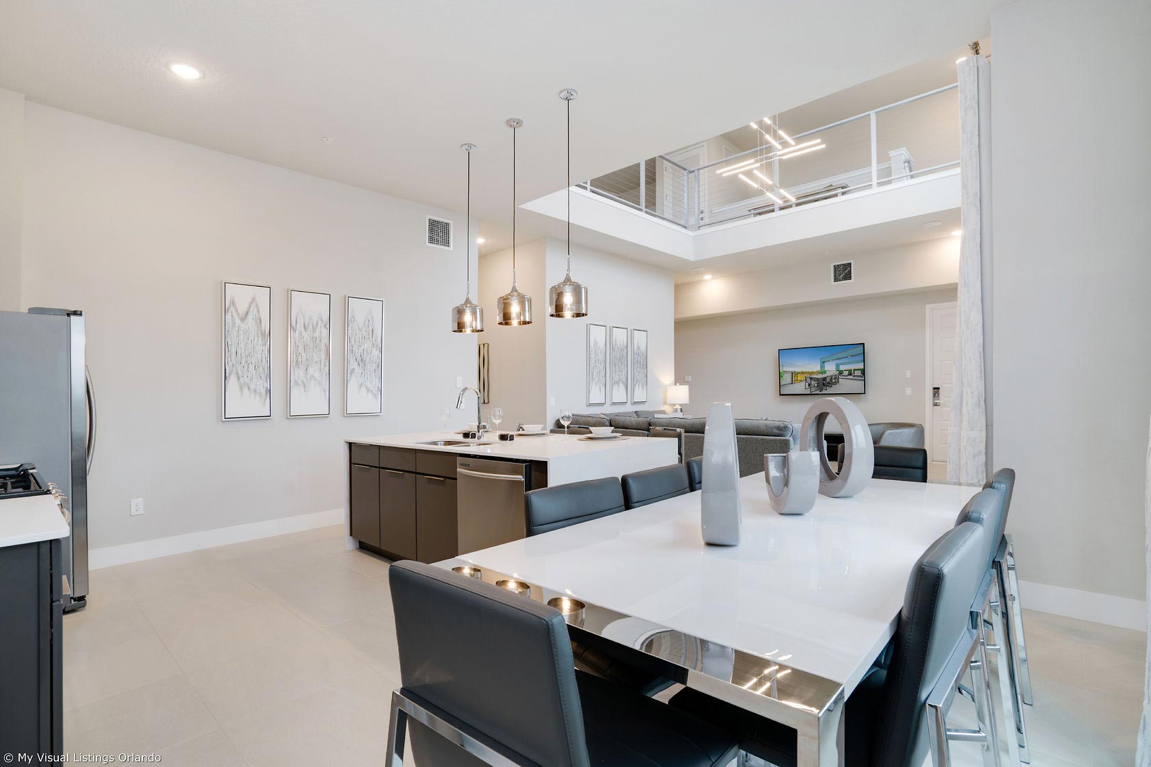 Home 21 Dining Room And Kitchen With View Of The Upper Floor Loft Of A Spectrum Resort Orlando Residence.