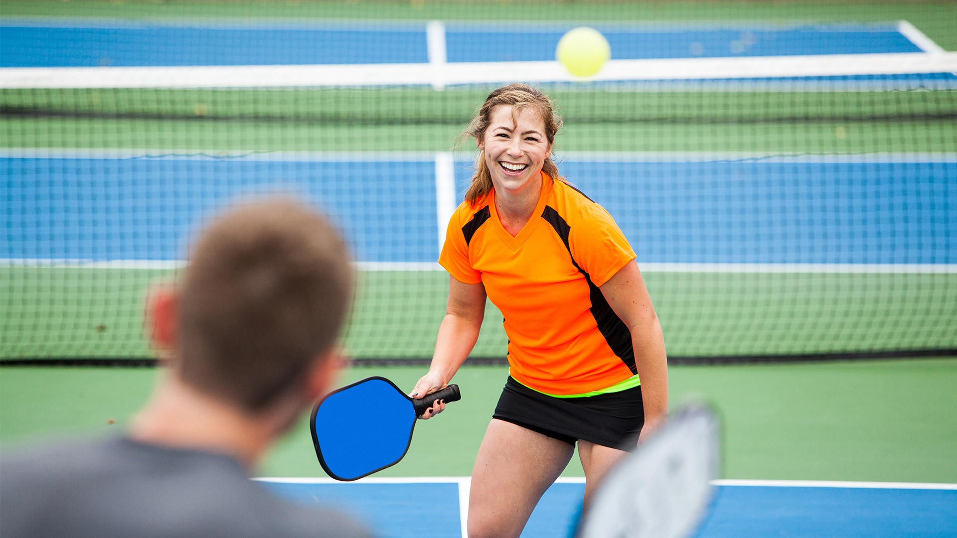 Home 28 Woman Playing Pickleball At Spectrum Resorts.