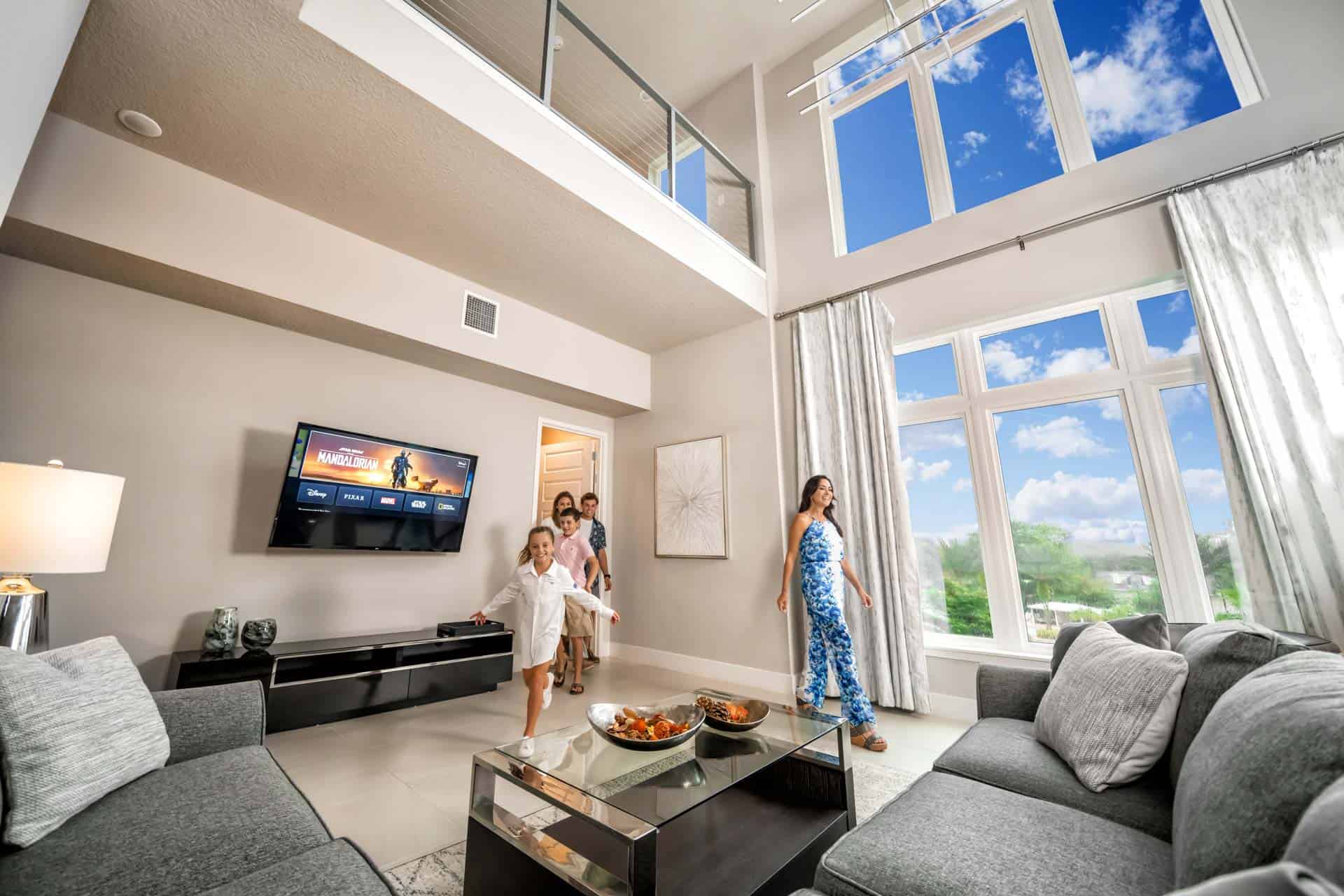 Home 11 Family Of Kids And Parents Running Into The Living Room Of A Spectrum Resort Orlando Residence With A Large Window.